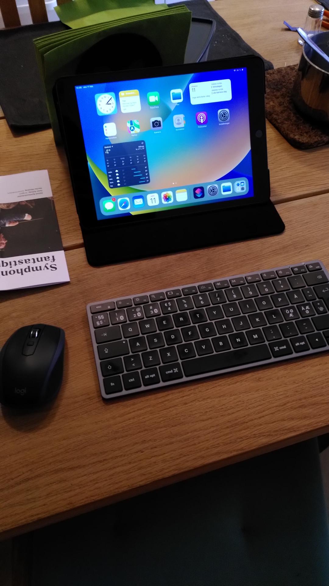 an iPad in a case with a slim wireless keyboard & mouse on a wooden table