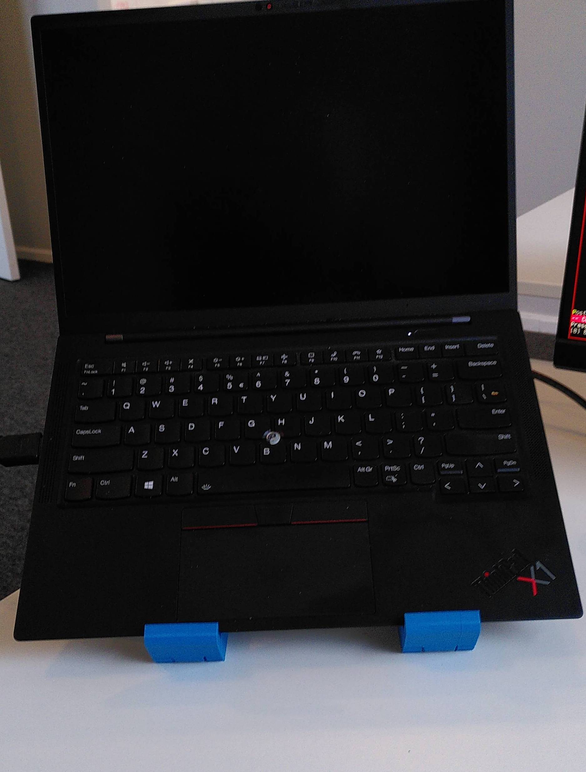A black Thinkpad laptop resting on top the the laptop stands.