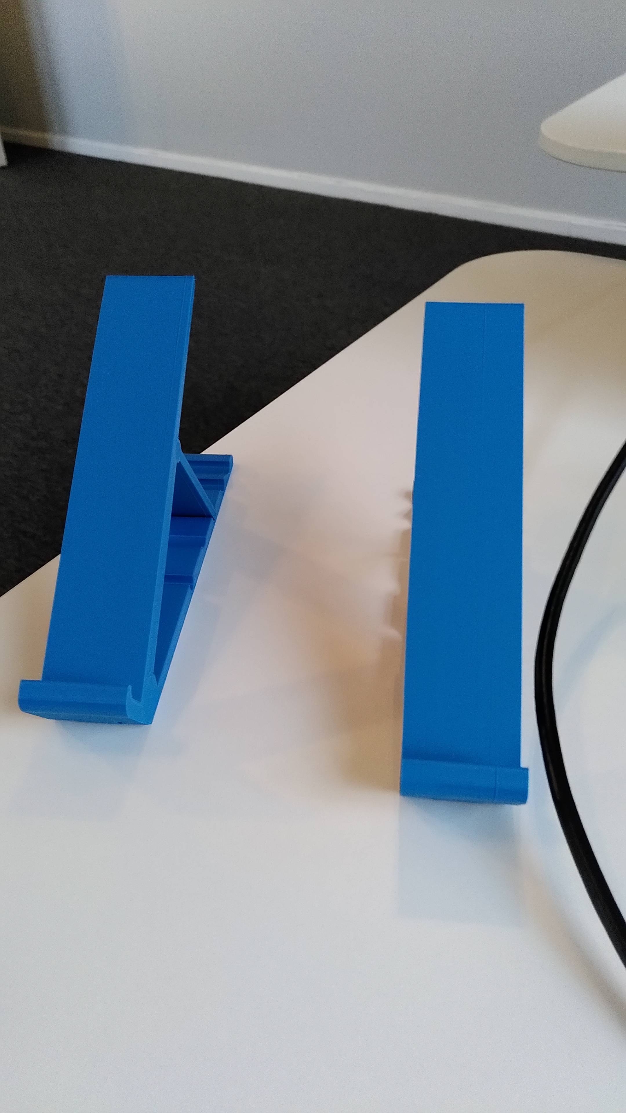 Two laptop stands in blue plastic with hinges.