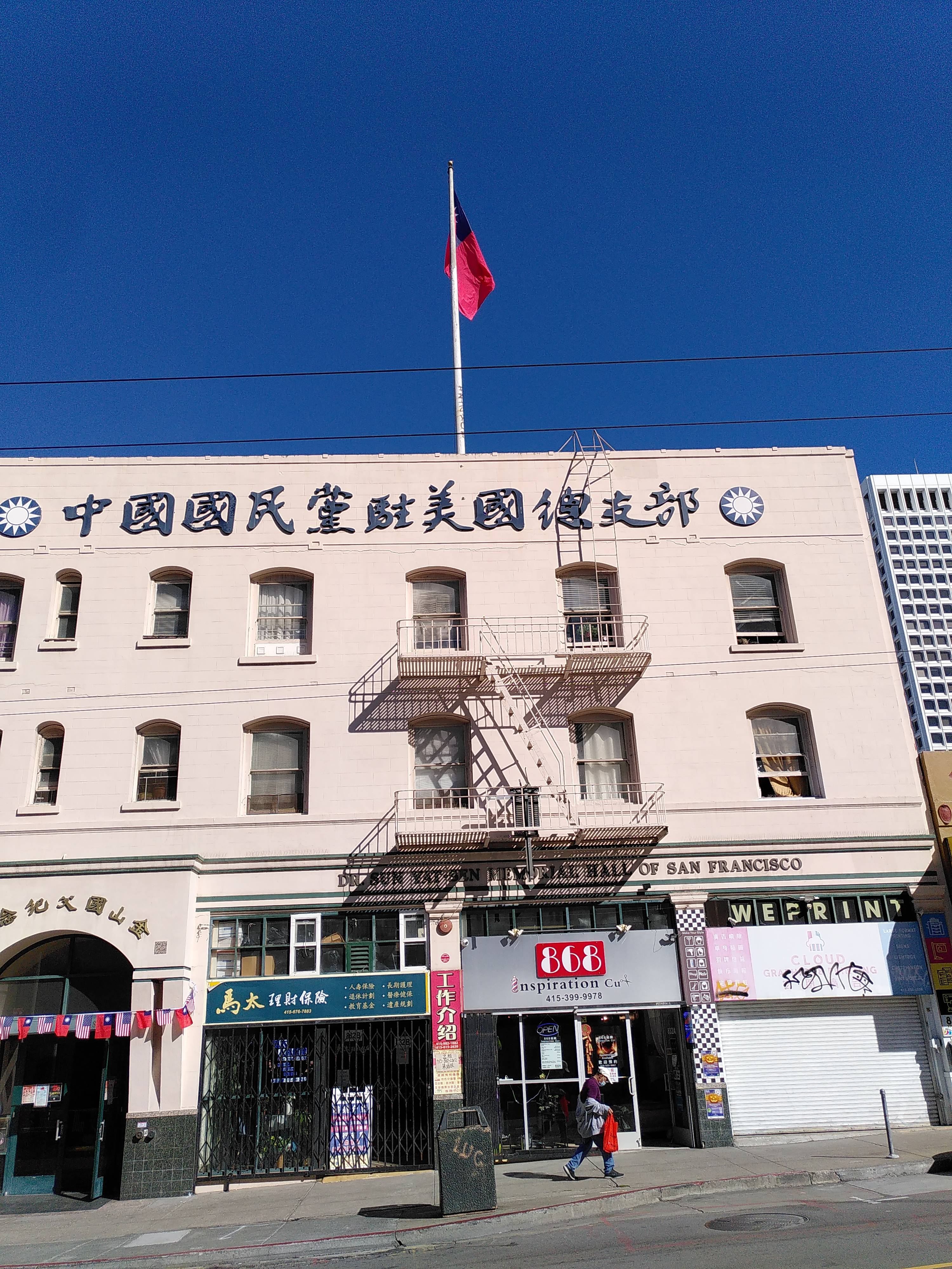 A white house with chinese characters and what looks like the Taiwanese flag on a flag pole.