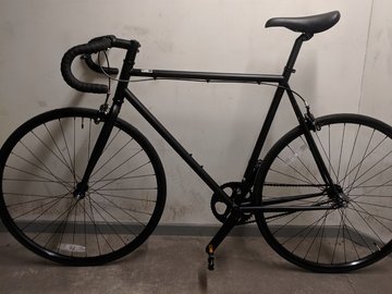 Matte black minimalist singlespeed bicycle with drop handles